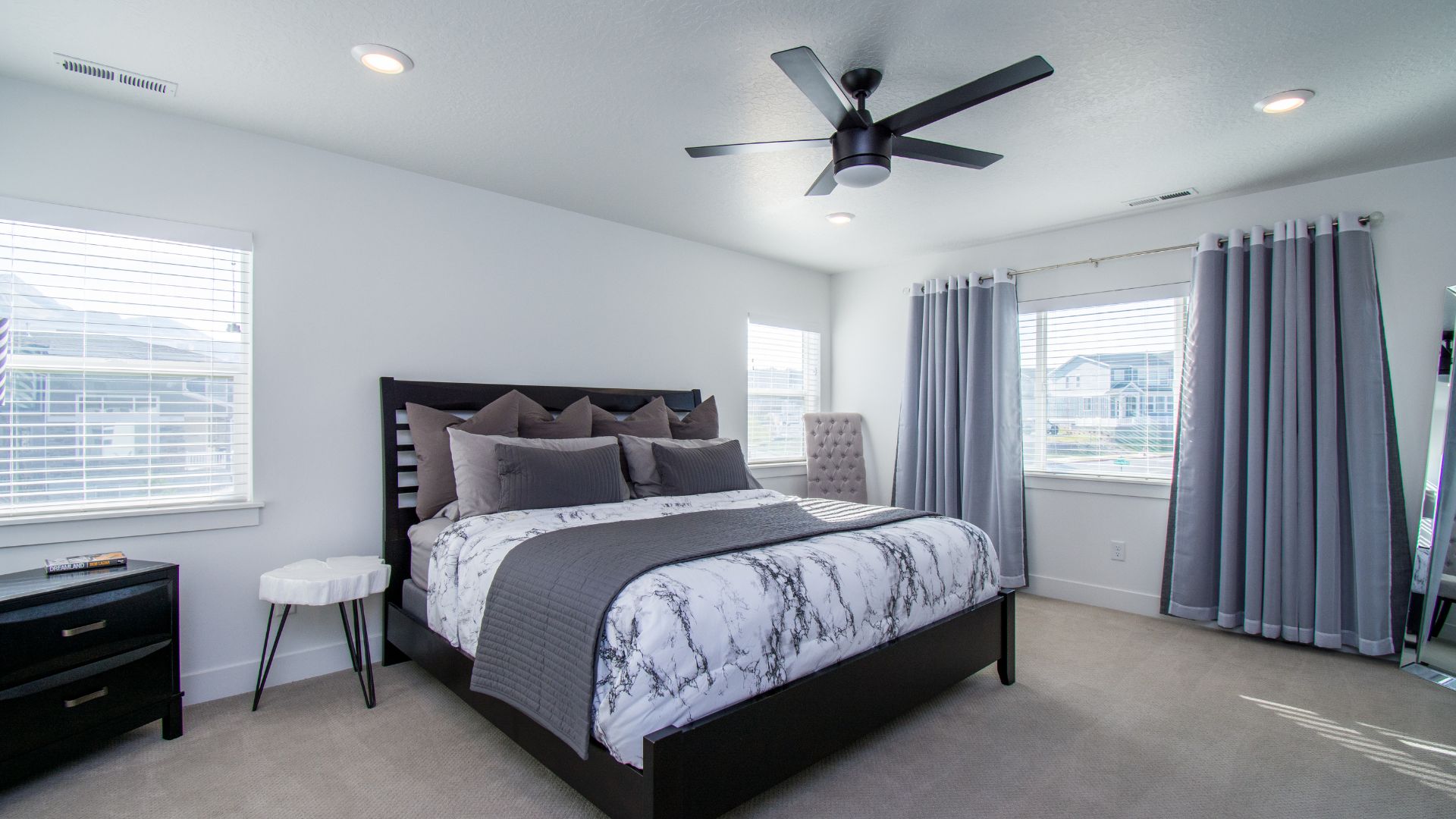 A bedroom with a large bed and a ceiling fan