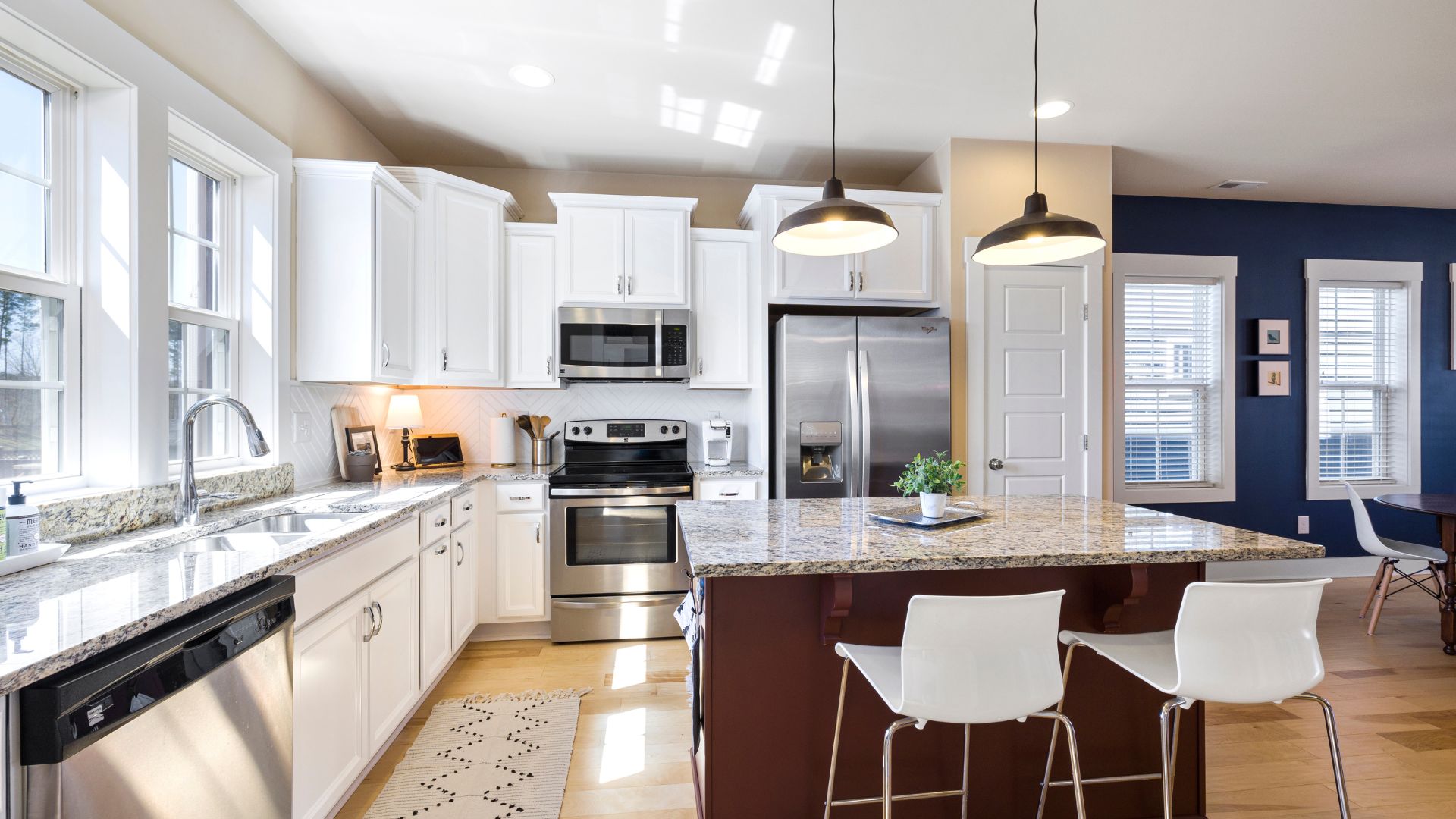 A kitchen with white cabinets and a center island