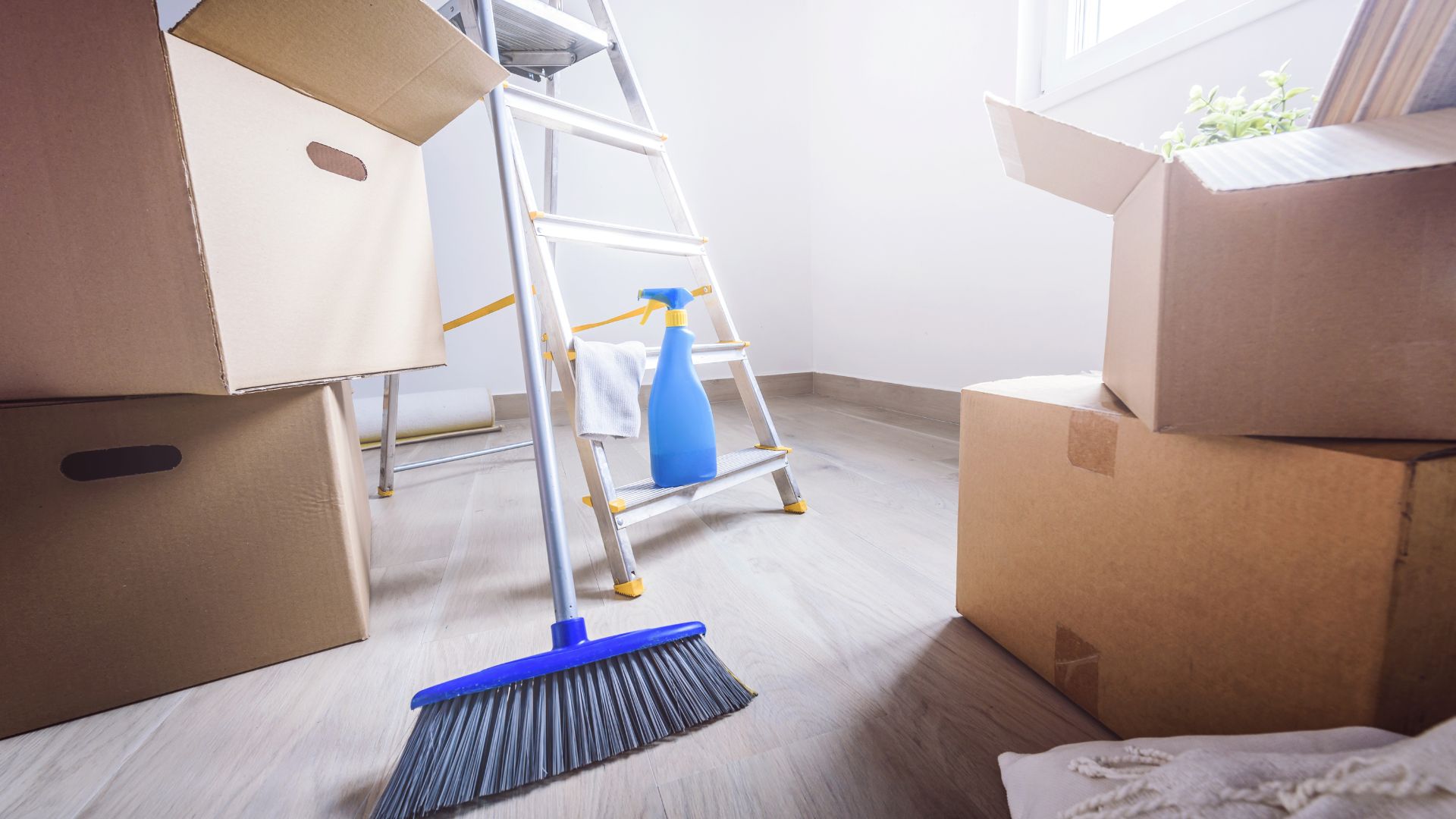 A room with boxes and a broom on the floor